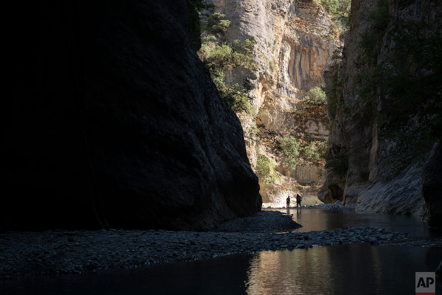  In this June 20, 2019 photo, people walk along the Langarica River, a tributary to the Vjosa near Permet, Albania. Albania's government has set in motion plans to dam the Vjosa and its tributaries to generate much-needed electricity for one of Europ