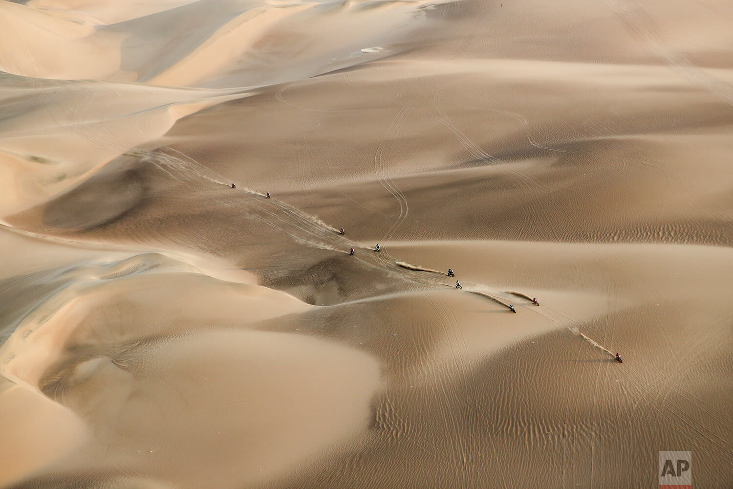  Competitors ride their motorcycles across the dunes during stage nine of the Dakar Rally in Pisco, Peru, on Jan. 16, 2019. (AP Photo/Ricardo Mazalan) 