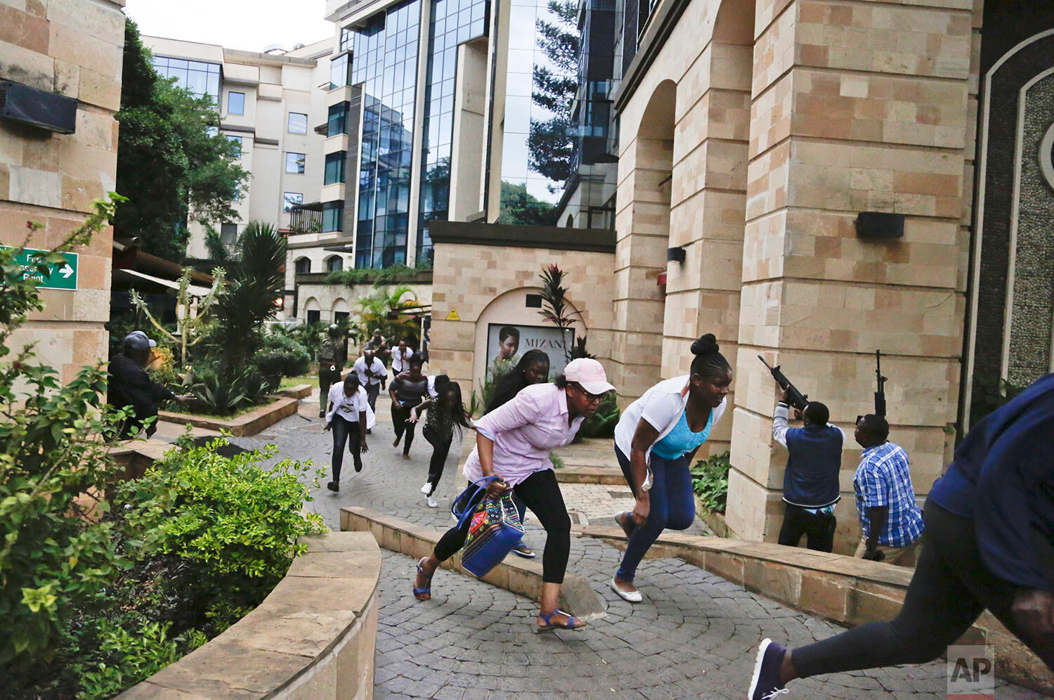  People flee as security forces aim their weapons during a deadly attack by extremists at a luxury hotel complex in Nairobi, Kenya, on Jan. 15, 2019. Explosions and heavy gunfire reverberated through the complex during the attack that killed more tha