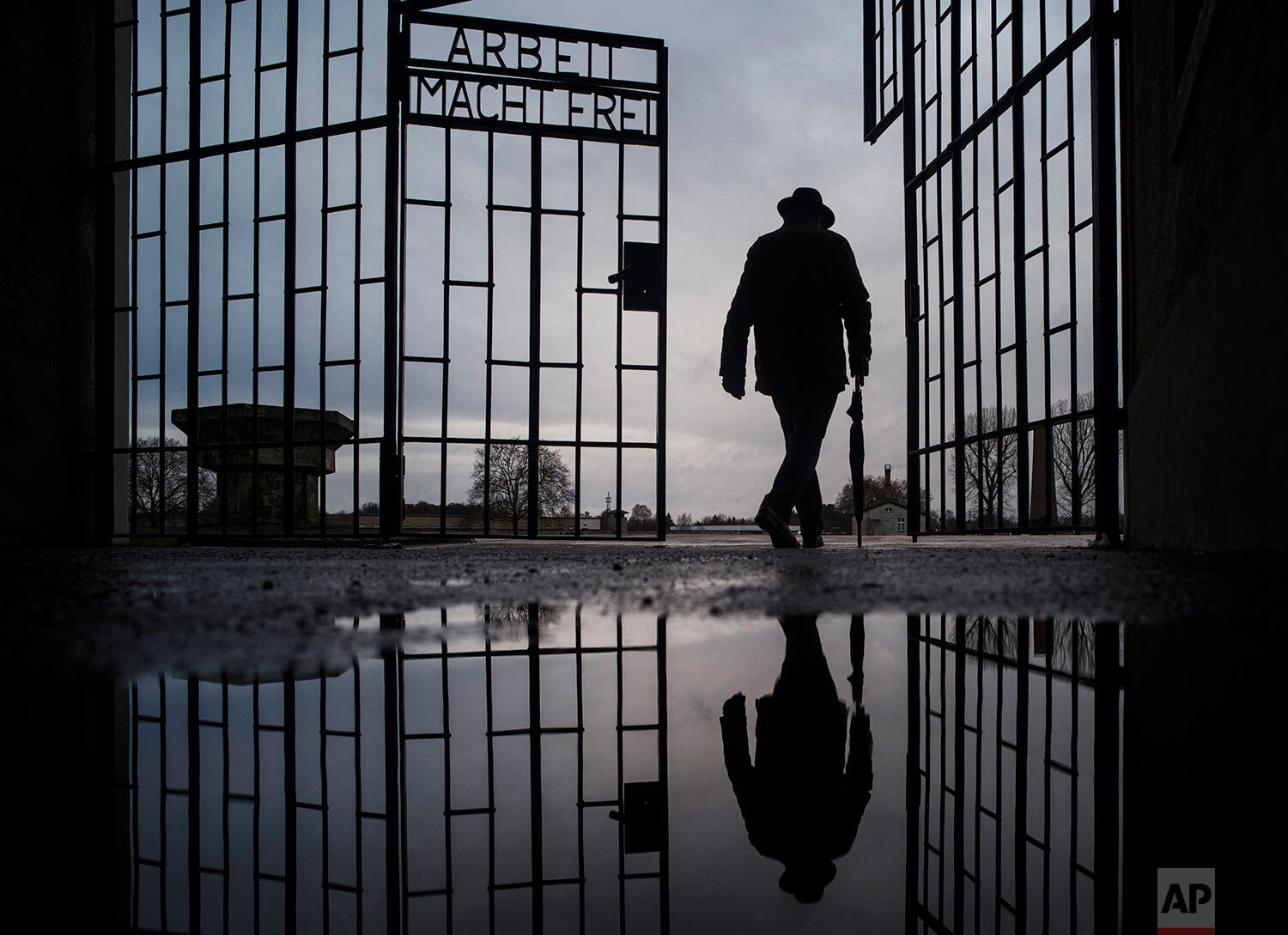  A man walks through the gate of the Sachsenhausen Nazi death camp with the phrase "Arbeit macht frei" (work sets you free) in Oranienburg, Germany, on International Holocaust Remembrance Day, Jan. 27, 2019. (AP Photo/Markus Schreiber) 