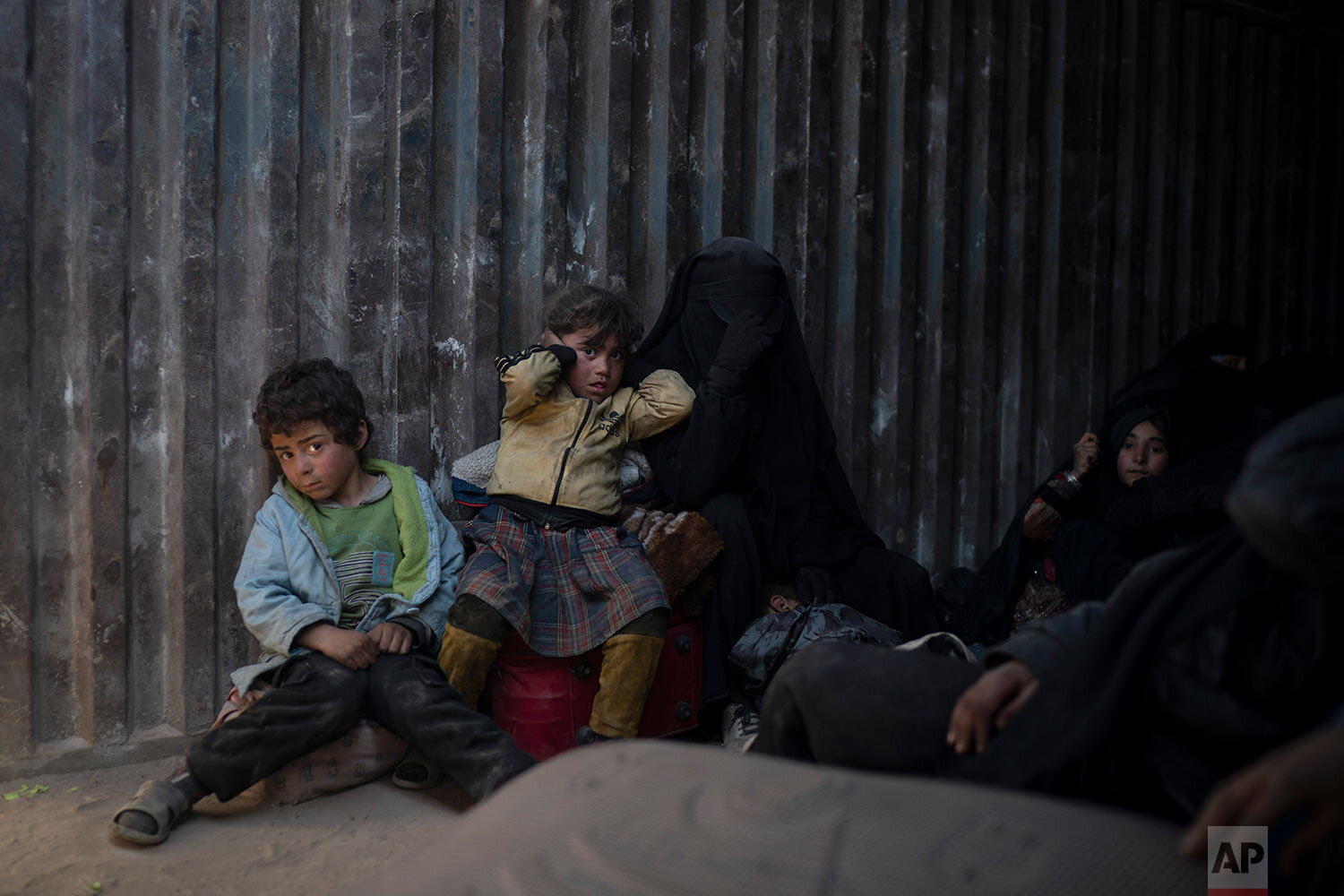  Women and children ride in the back of a truck that is part of a convoy evacuating hundreds out of the last territory held by Islamic State militants in Baghouz, Syria, on Feb. 20, 2019. (AP Photo/Felipe Dana) 