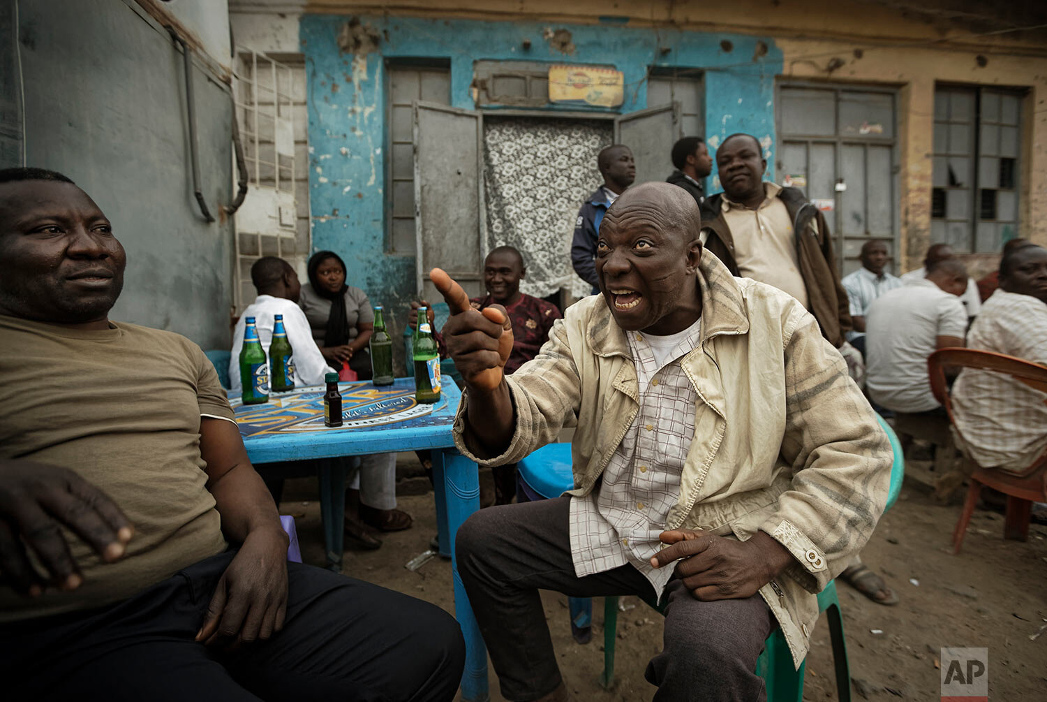  Nigerians engage in heated but friendly arguments about the postponement of the election, over beers at a street-side bar in the predominantly-Christian neighborhood of Sabon Gari in Kano, northern Nigeria, on Feb. 16, 2019. (AP Photo/Ben Curtis) 