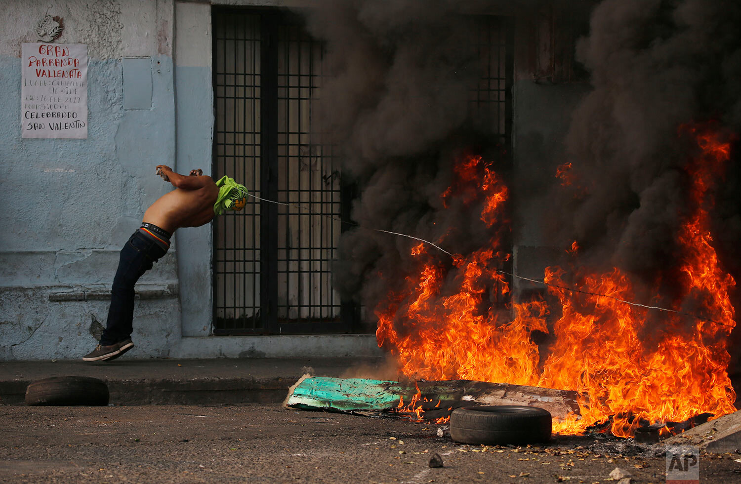  A demonstrator is knocked over by a strand of barbed wire during clashes with the Bolivarian National Guard in Urena, Venezuela, near the border with Colombia on Feb. 23, 2019. (AP Photo/Fernando Llano) 