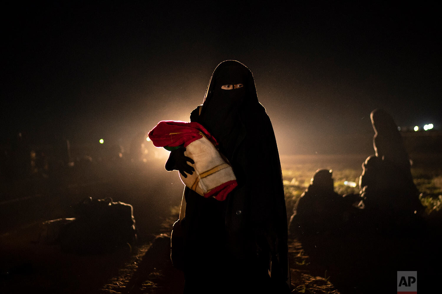  A woman and her baby, who were evacuated from the last territory held by Islamic State militants, walk after being screened by U.S.-backed Syrian Democratic Forces (SDF) in the desert outside Baghouz, Syria, on Feb. 25, 2019. (AP Photo/Felipe Dana) 