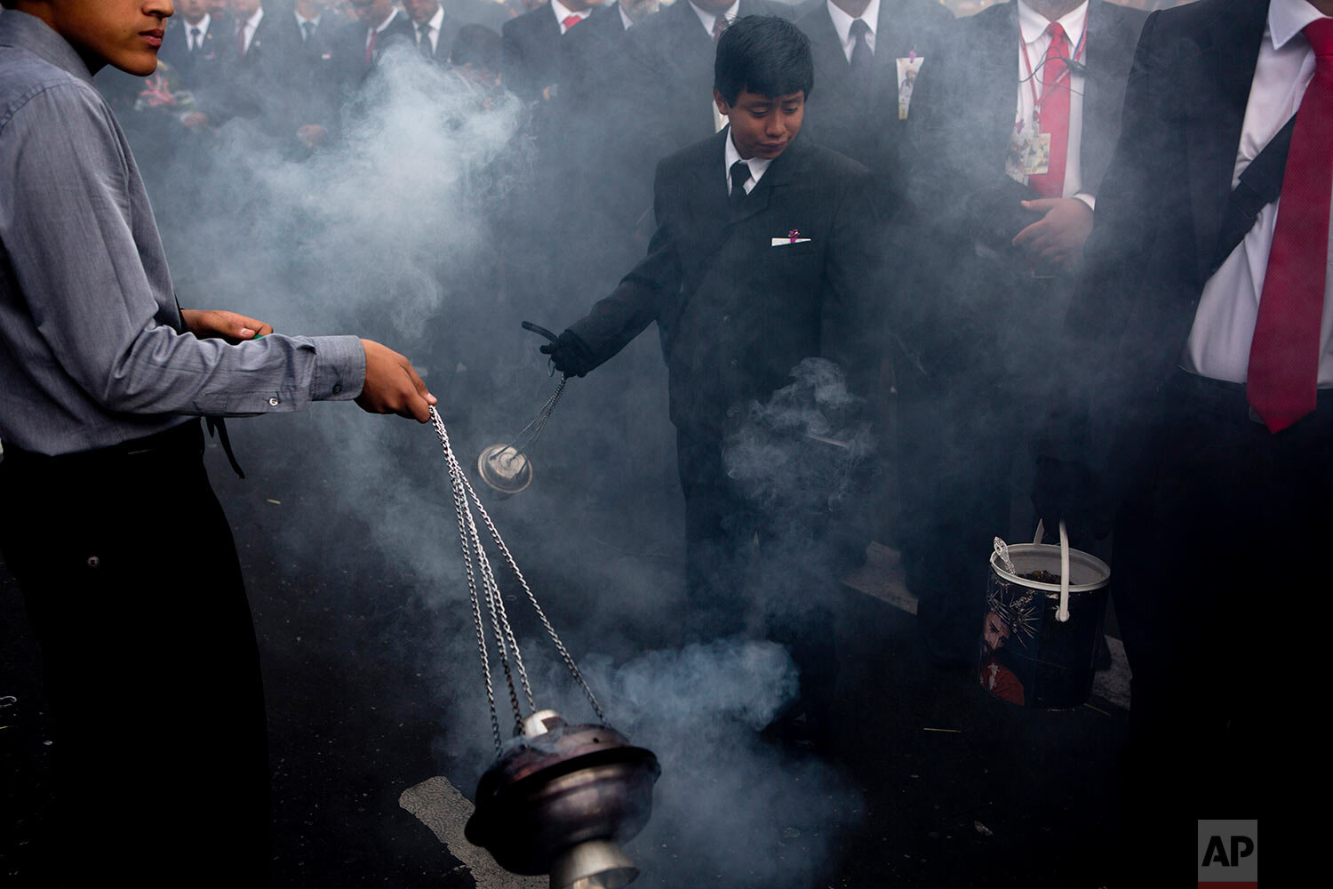  Boys swing censers using the smoke from incense to purify the path of the Holy Tuesday procession known as "La Resena," in downtown Guatemala City on April 16, 2019. (AP Photo/Moises Castillo) 