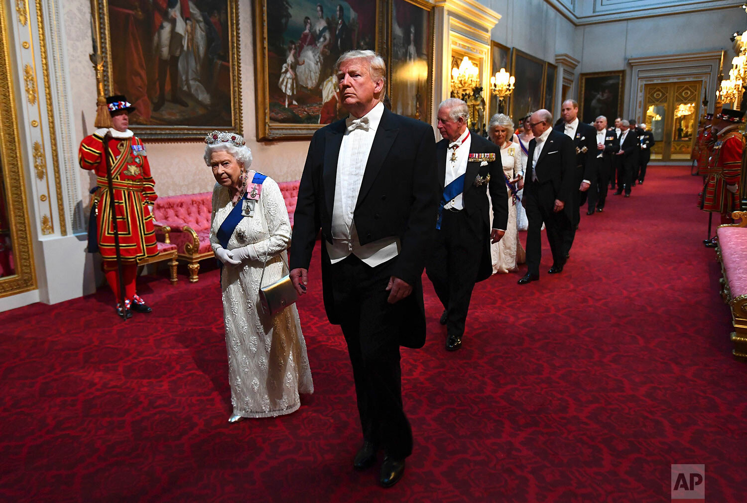  Queen Elizabeth II and U.S. President Donald Trump arrive with others through the East Gallery at Buckingham Palace in London ahead of the State Banquet on June 3, 2019. (Victoria Jones/Pool Photo via AP) 