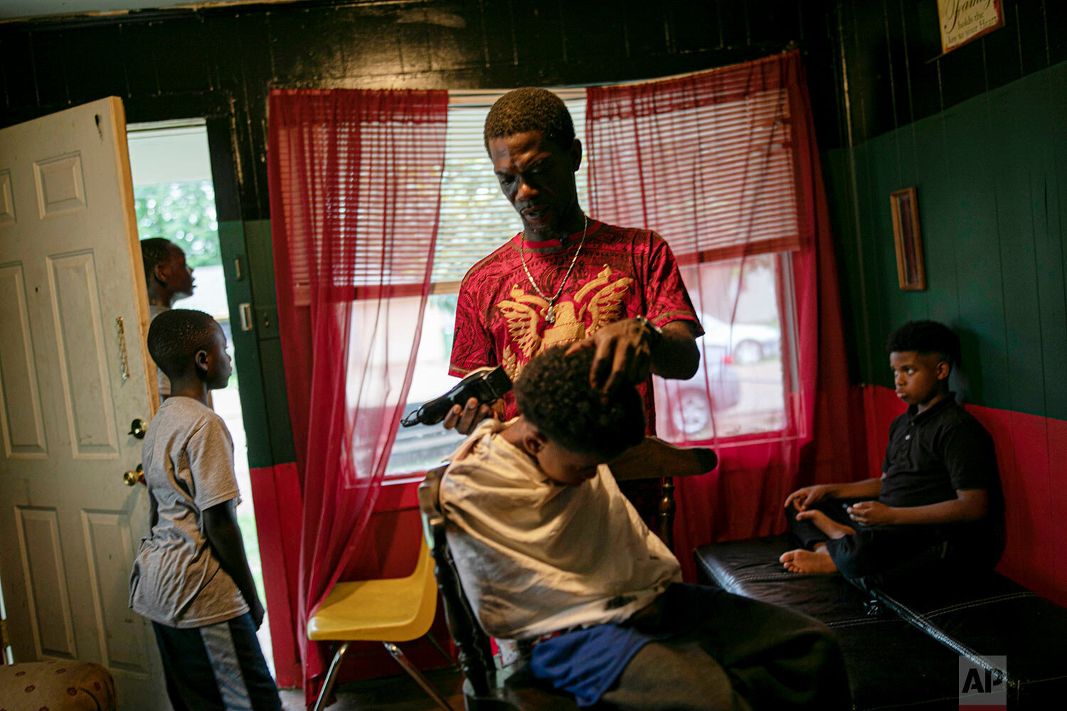  Joshua K. Love gives a haircut to his nephew, Jintarius Turner Love, 7, at Love's home in Greenwood, Miss., on June 8, 2019. Love never graduated from the Catholic grade school where he says he was sexually abused, and today he can't read or write w