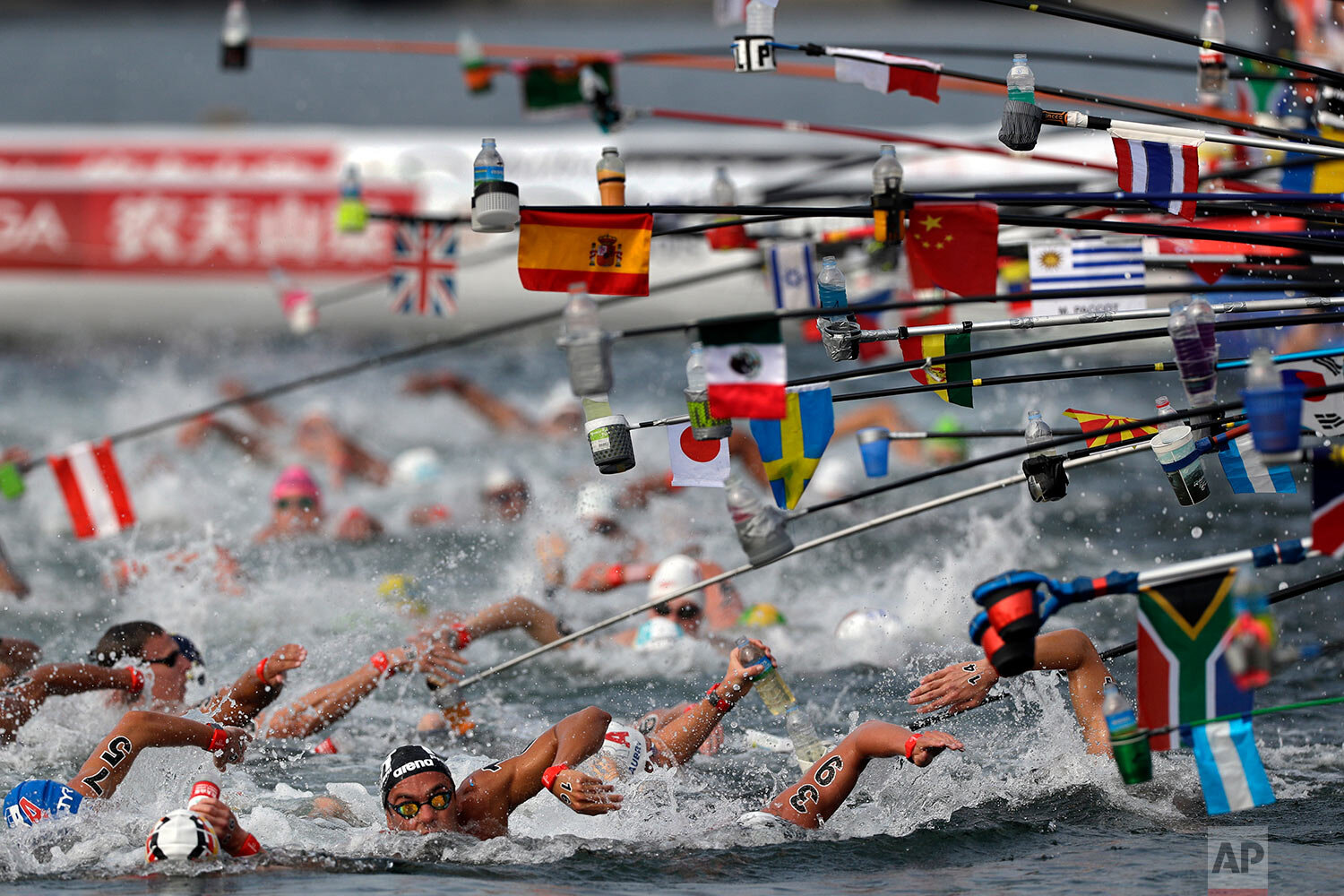  Swimmers reach for drink bottles while competing in the men's 10km open water swim at the World Swimming Championships in Yeosu, South Korea, on July 16, 2019. (AP Photo/Mark Schiefelbein) 