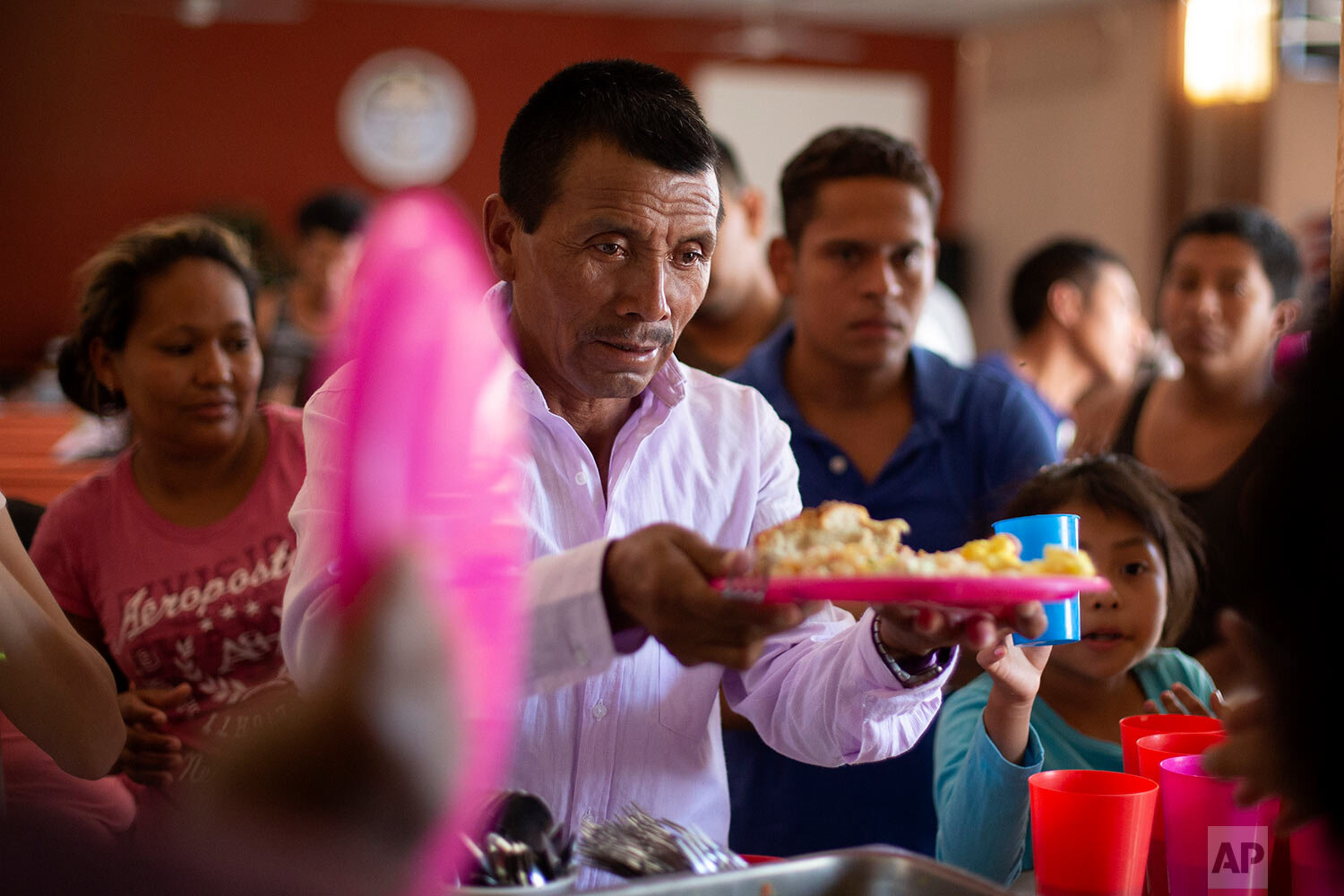  A Guatemalan man gets a plate of food at El Buen Pastor shelter for migrants in Ciudad Juarez, Mexico, on July 25, 2019. (AP Photo/Gregory Bull) 