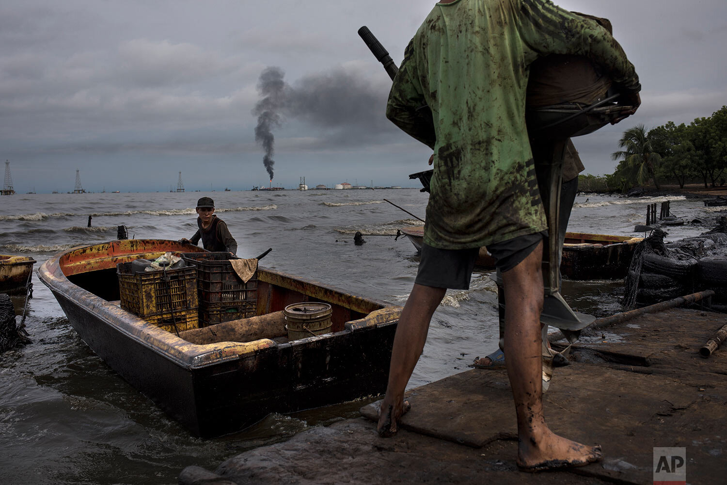  Fishermen covered in oil prepare their boat for fishing on Lake Maracaibo near La Salina crude oil shipping terminal in Cabimas, Venezuela, on July 9, 2019. (AP Photo/Rodrigo Abd) 