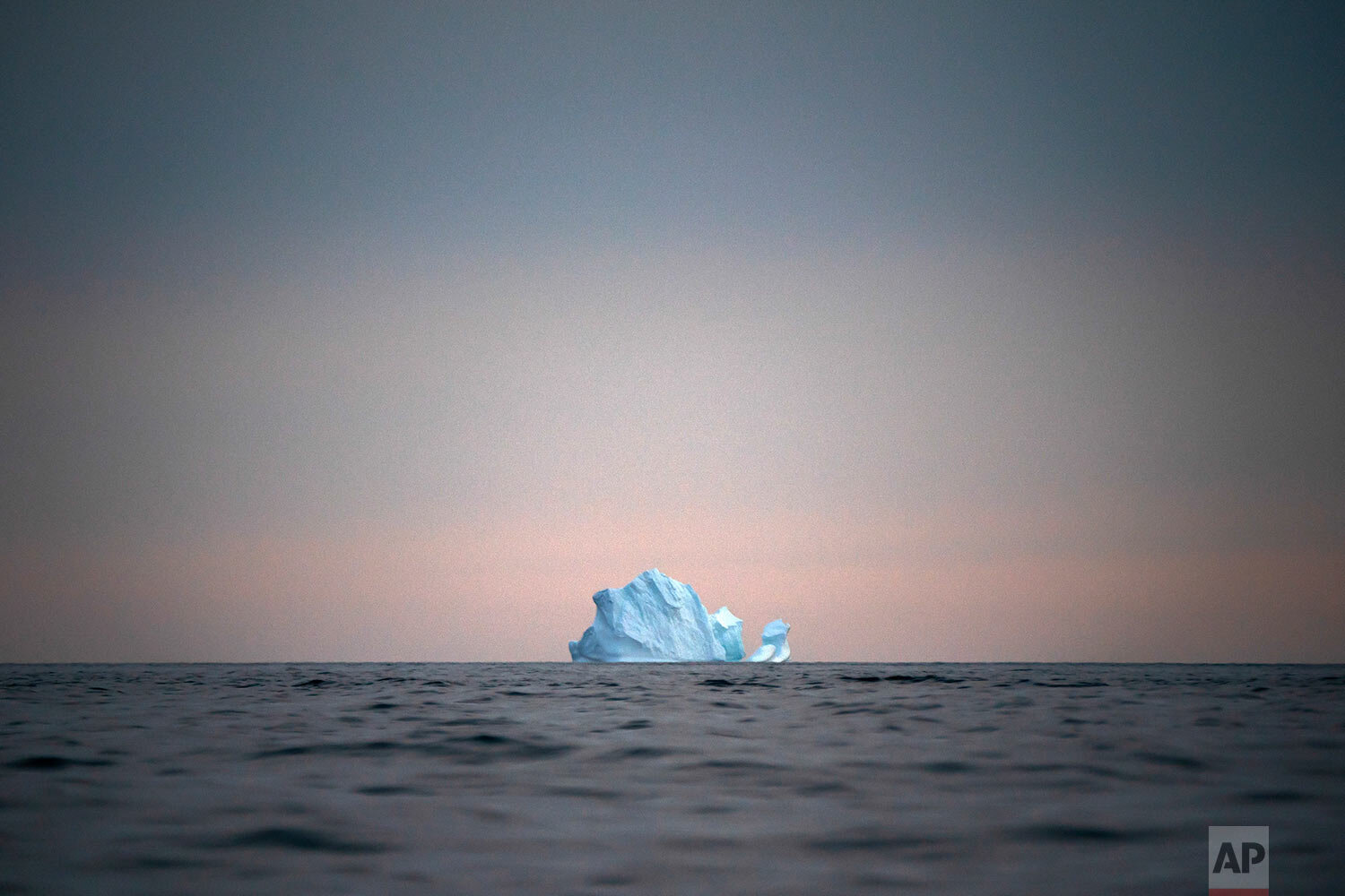  A large Iceberg floats away as the sun sets near Kulusuk, Greenland, on Aug. 15, 2019. (AP Photo/Felipe Dana) 