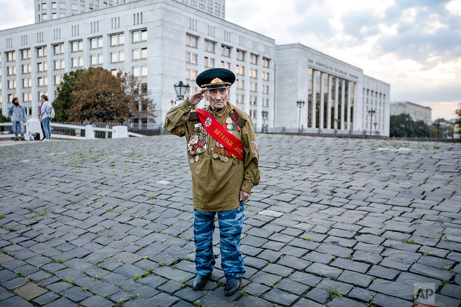  World War II veteran Lev Yatsevich, 92, salutes as he waits for other participants of an event marking the anniversary of the failed August 1991 hard-line coup outside the former Russian parliament building, which now houses the Russian Cabinet, in 