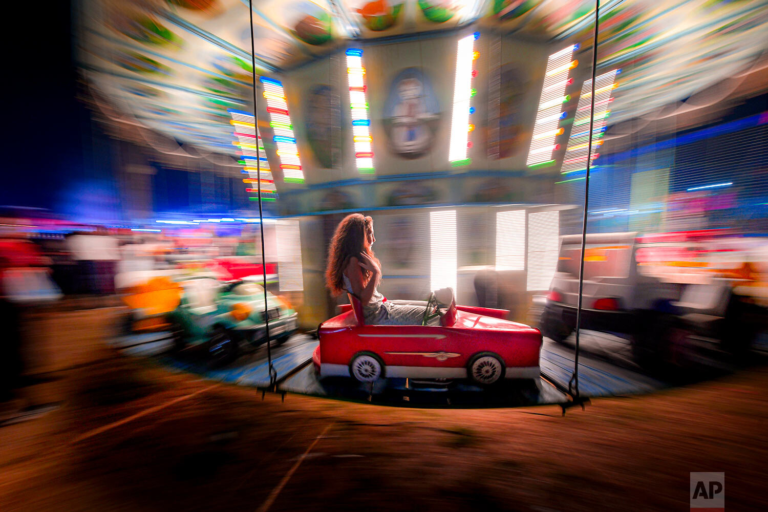  A little girl holds her hair while riding a merry go round at an autumn fair in Rosiorii de Vede, southern Romania, on Sept. 7, 2019. (AP Photo/Andreea Alexandru) 