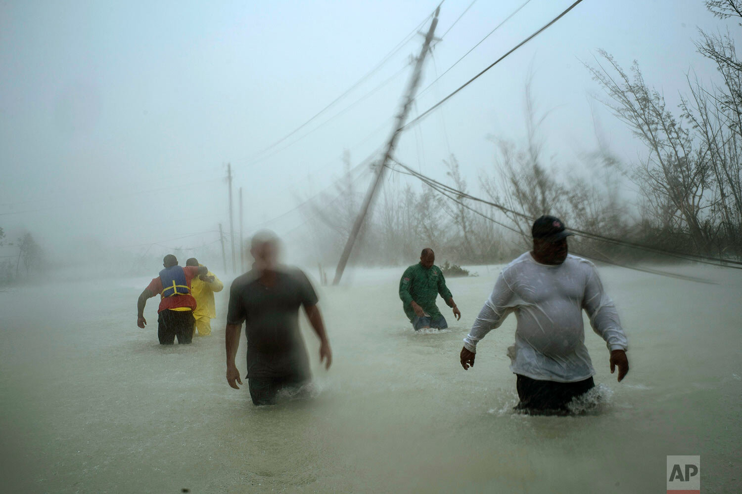  Volunteers wade through a flooded road against wind and rain brought on by Hurricane Dorian to rescue families near the Causarina bridge in Freeport, Grand Bahama, Bahamas, on Sept. 3, 2019. (AP Photo/Ramon Espinosa) 