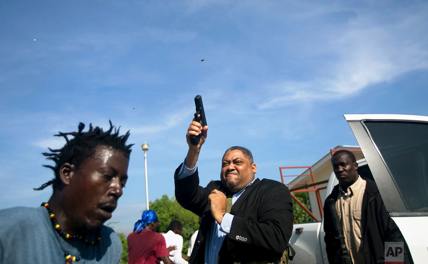  Ruling party Sen. Ralph Fethiere fires his gun outside Parliament as he arrives for a vote on the ratification of Fritz William Michel's nomination as prime minister in Port-au-Prince, Haiti, on Sept. 23, 2019. Opposition members confronted ruling-p