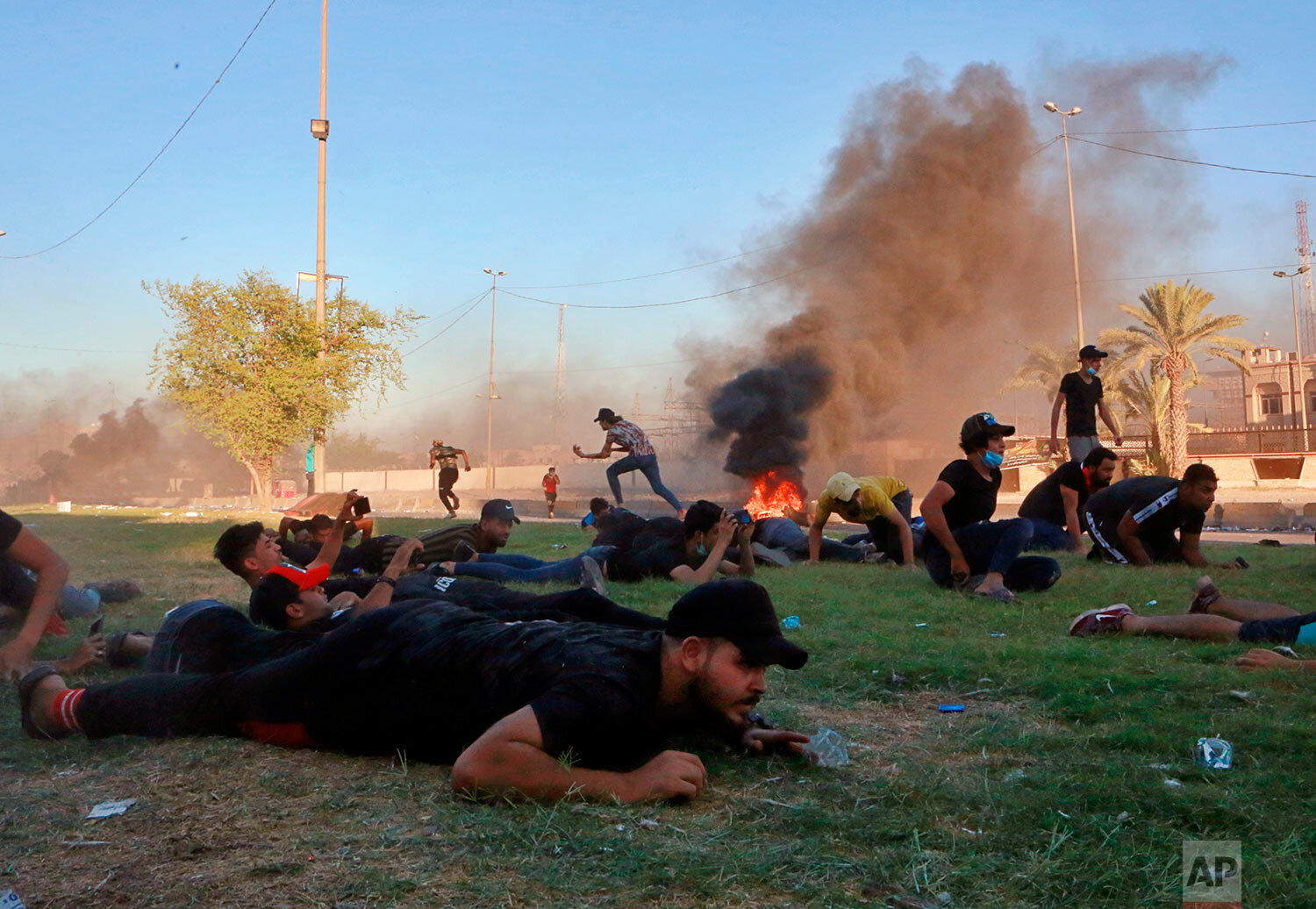  Anti-government protesters take cover during a demonstration in Baghdad, Iraq, as security forces open fire on Oct. 4, 2019. (AP Photo/Khalid Mohammed) 