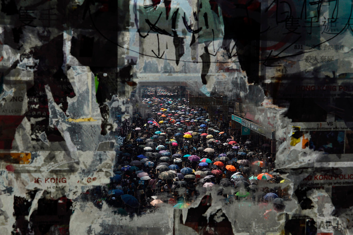  Marching anti-government protesters are seen through a window with peeled off posters in Hong Kong on Oct. 1, 2019. (AP Photo/Vincent Yu) 