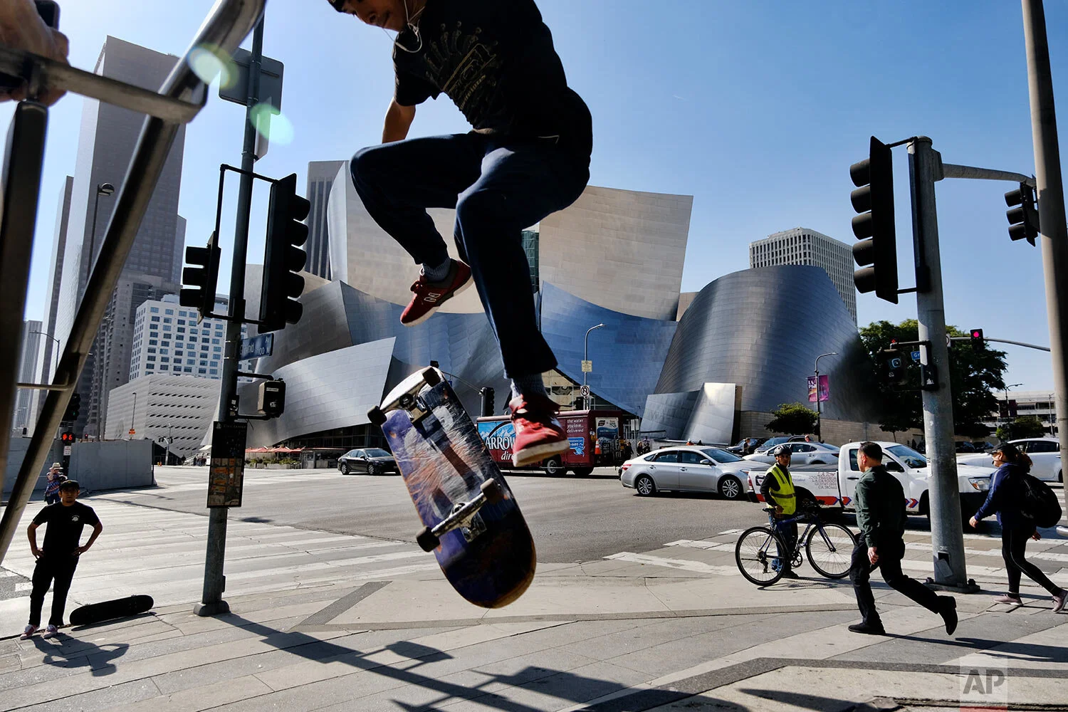A skateboarder attempts to jump a small staircase across the street from the Walt Disney Concert Hall in downtown Los Angeles on Oct. 29, 2019. (AP Photo/Richard Vogel)