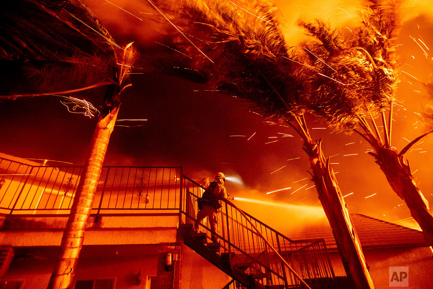  A firefighter sprays water while embers threaten a residence as the Hillside fire burns through San Bernardino, Calif., on Oct. 31, 2019. (AP Photo/Noah Berger) 