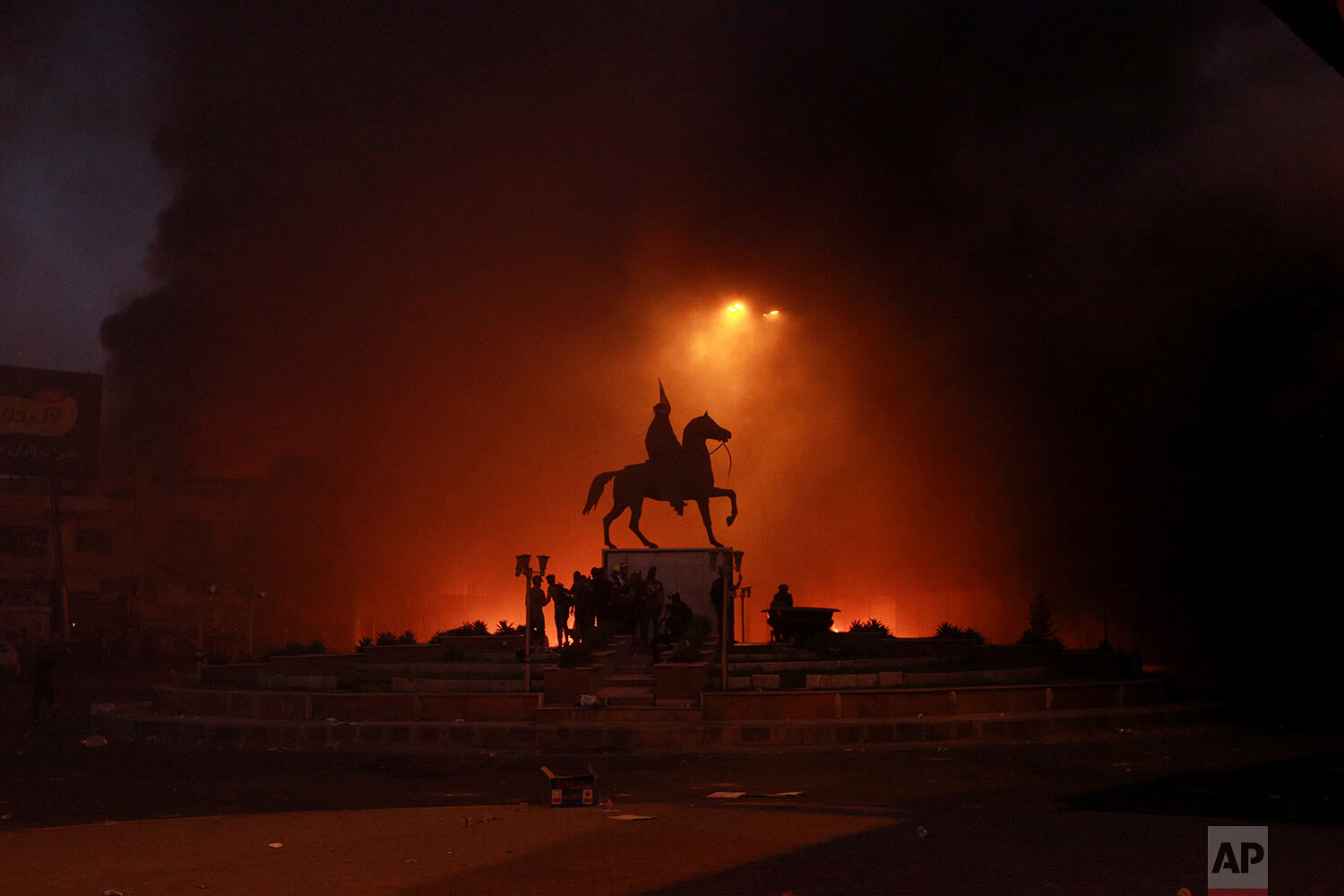  Anti-government protesters set fires in Baghdad, Iraq, while security forces fire live ammunition and tear gas near the state-run television station on Nov. 4, 2019. (AP Photo/Hadi Mizban) 