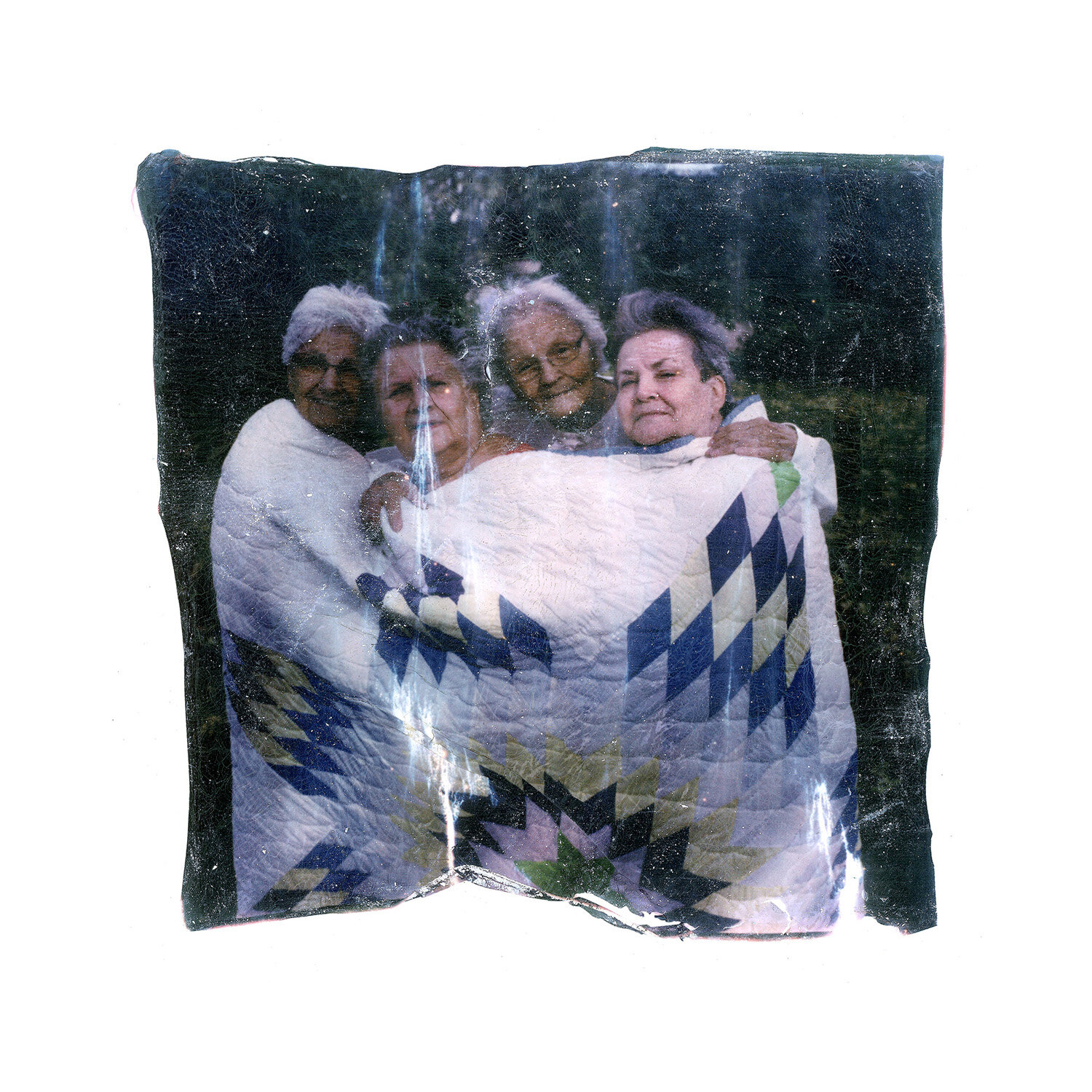 The Charbonneau sisters, from left to right, Francine Soli, 71, Barbara Dahlen, 67, Joann Braget, 78, and Louis Aamot, 69, pose in a quilt made by their mother, in Walhalla, ND., on Tuesday, Oct. 8, 2019. The sisters who are Native American, say they were sexually abused at a Catholic school on reservation. (AP Photo/Wong Maye-E)