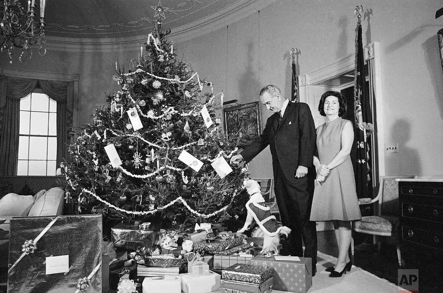  President Lyndon Johnson and Lady Bird Johnson, and Yuki, the White House pet, pose beside the family Christmas tree in Washington, Dec. 24, 1967, a Norway spruce. (AP Photo) 