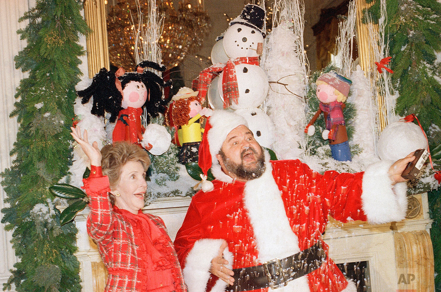  First Lady Nancy Reagan, left, and Santa, Dom DeLuise, throw some artificial snow in the air during a press preview of White House decorations, Monday, Dec. 14, 1987, Washington, D.C. (AP Photo/Barry Thumma) 