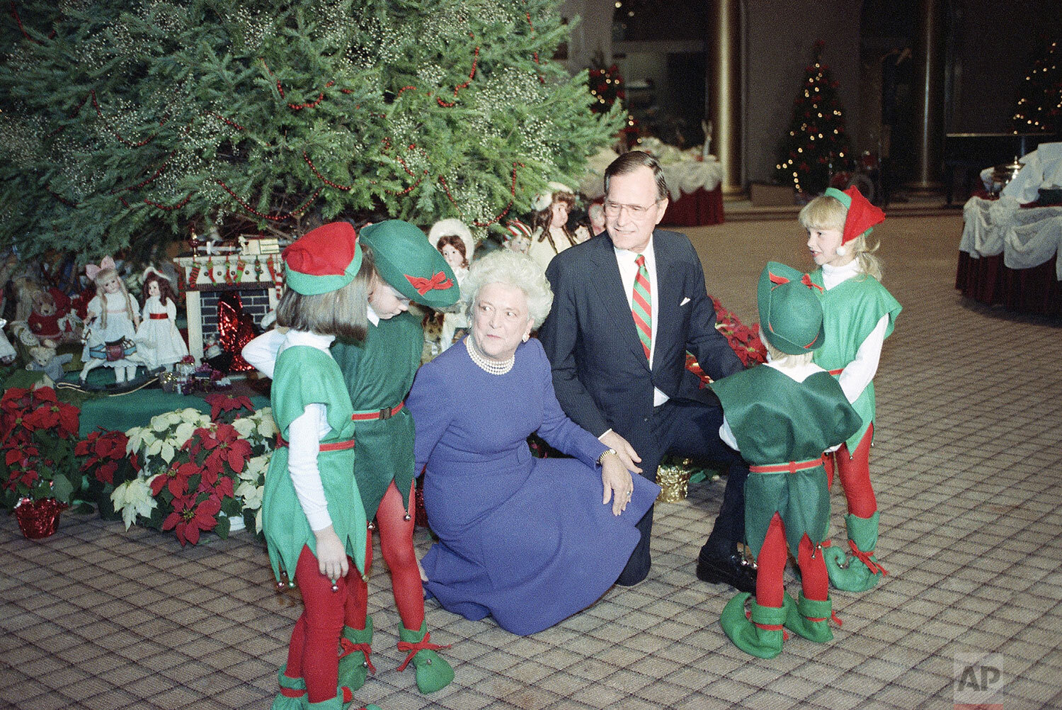  U.S. President George Bush and Barbara Bush pose with children dressed as elves while attending the taping of NBC's "Christmas in Washington" Sunday, Dec. 10, 1989 in Washington. (AP Photo/Charles Tasnadi) 