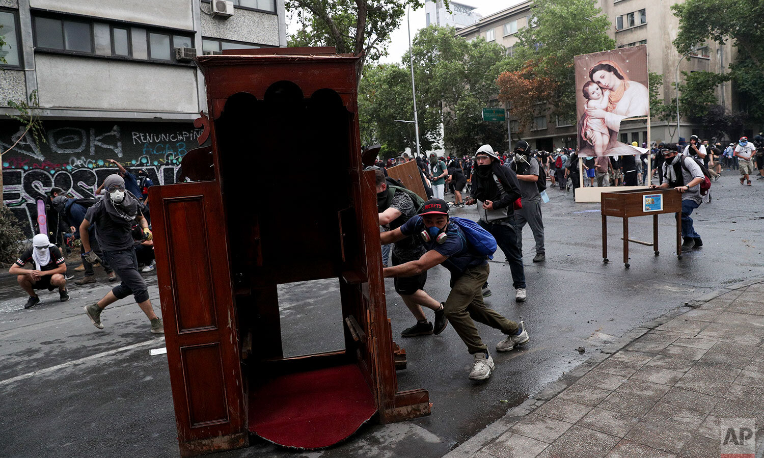  Anti-government protesters drag items from a church to be added to a barricade, in Santiago, Chile, Friday, Nov. 8, 2019.  Chile's president on Thursday announced measures to increase security and toughen sanctions for vandalism following three week