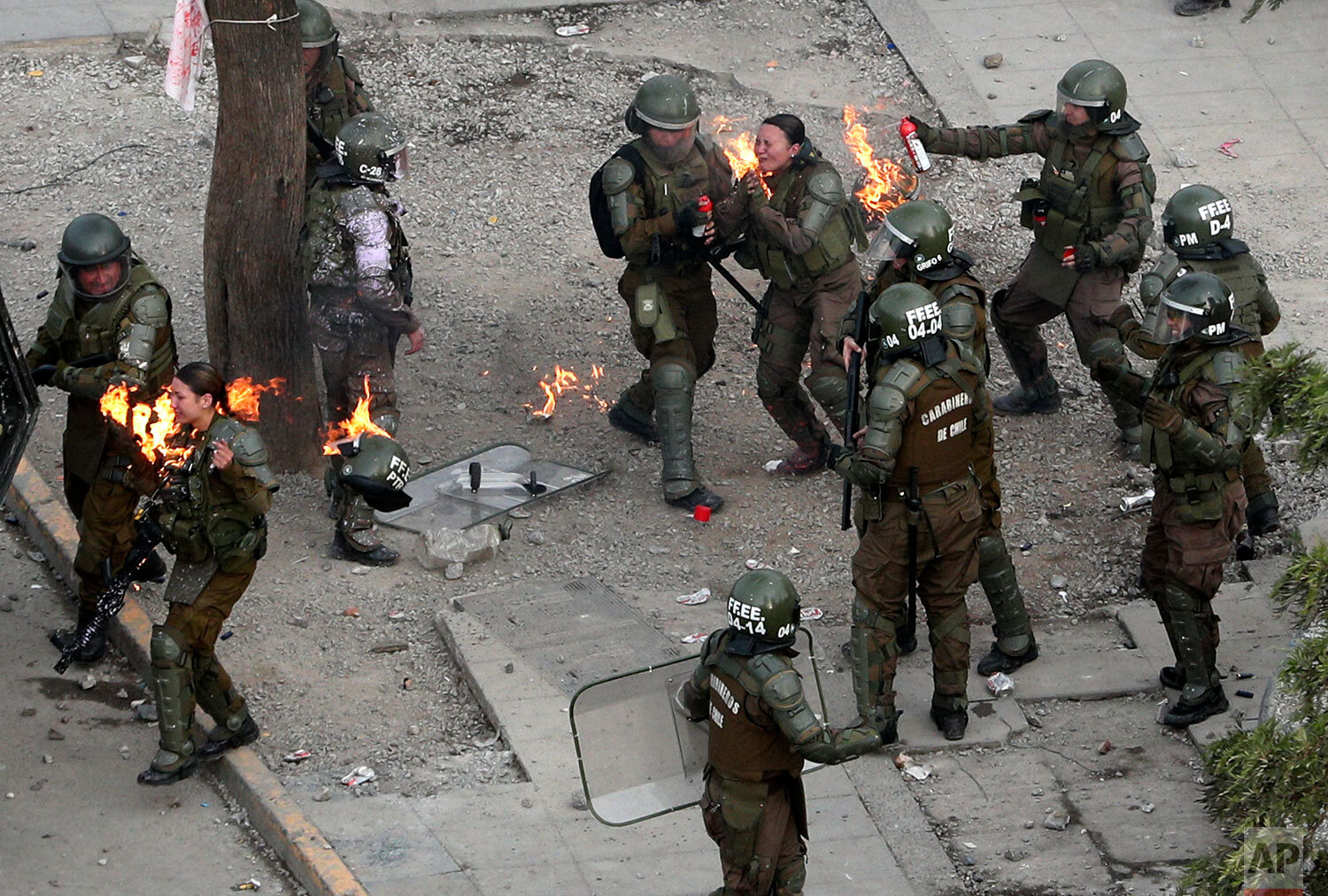  Police officers run to get assistance after being hit with a gasoline bomb thrown by protesters during an anti-government protest in Santiago, Chile, Monday, Nov. 4, 2019. Chile has been facing weeks of unrest, triggered by a relatively minor increa