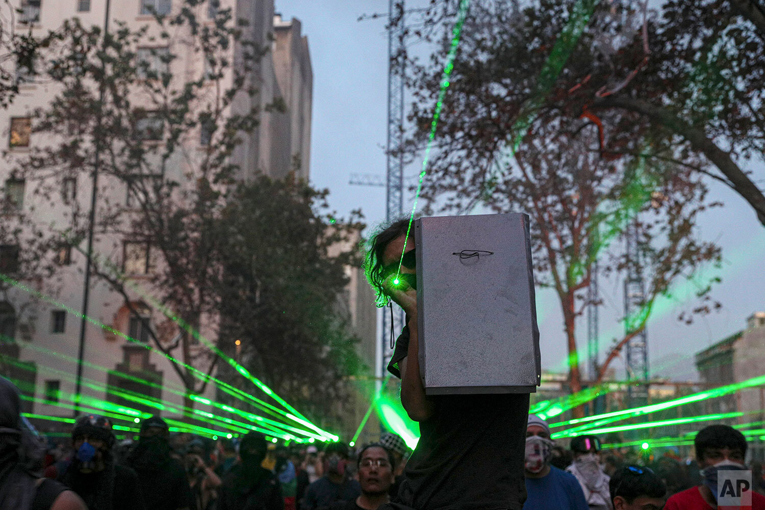  Anti-government demonstrators shine laser pointers a the police during a protest in Santiago, Chile, Thursday, Nov. 14, 2019. Students in Chile began protesting nearly a month ago over a subway fare hike. The demonstrations have morphed into a massi