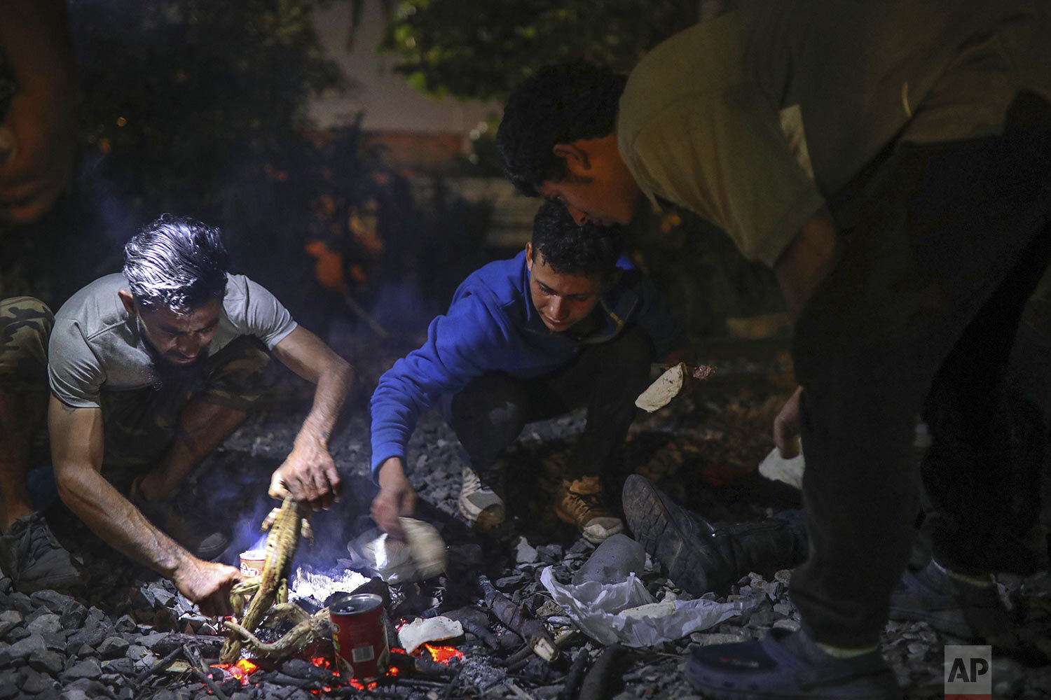  In this Nov. 21, 2019 photo, Central American migrants cook iguanas that they hunted with a slingshot next to the railroad tracks that they hope will take them north, in Coatzacoalcos, Veracruz state, Mexico. (AP Photo/Felix Marquez) 