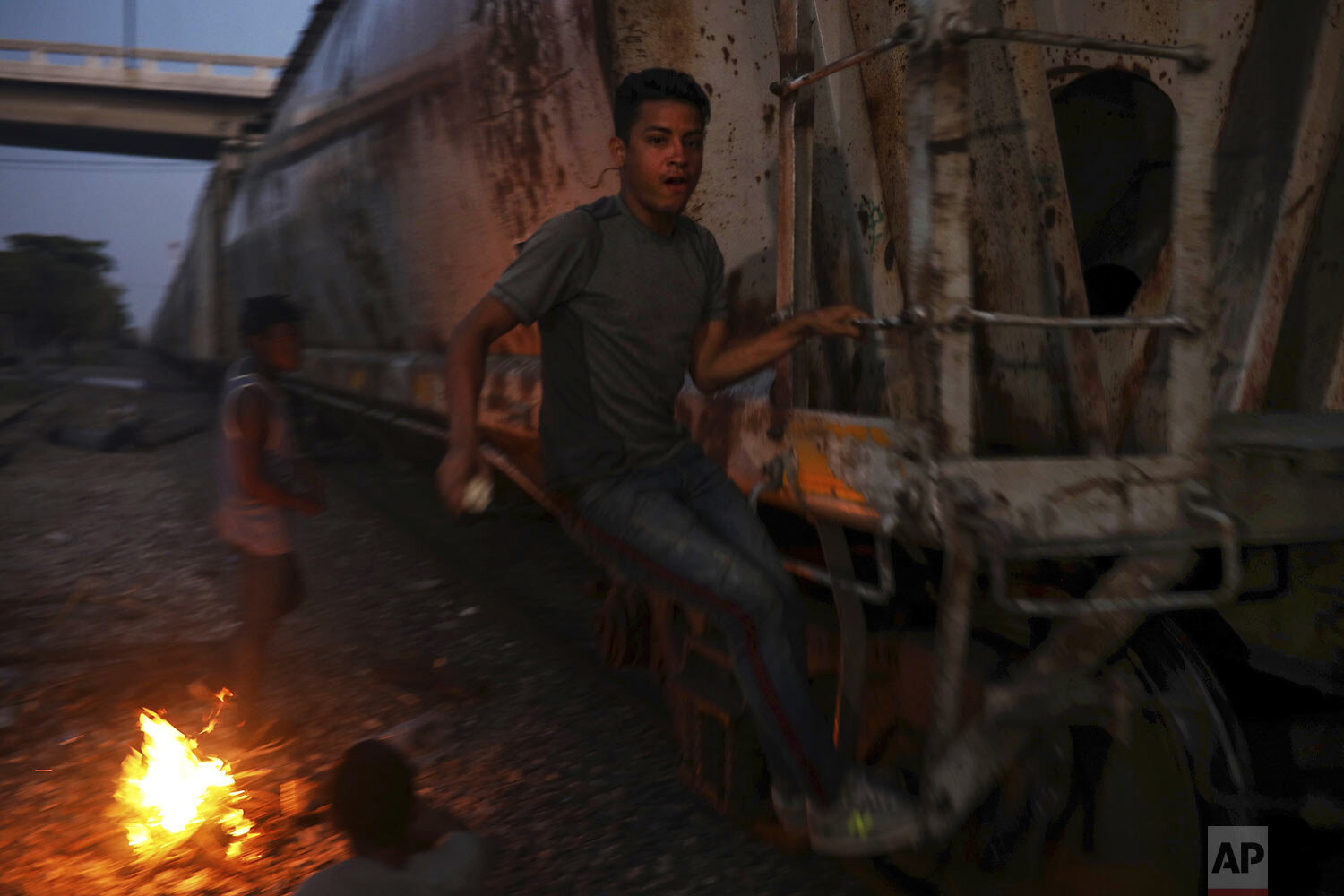  In this Nov. 21, 2019 photo, a Central American migrant climbs on a railroad car during his journey north, in Coatzacoalcos, Veracruz state, Mexico. (AP Photo/Felix Marquez) 