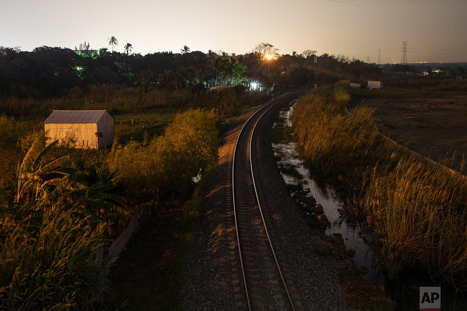  In this Nov. 21, 2019 photo, the sun sets over Coatzacoalcos, where migrants ride northern bound freight trains through Veracruz state, Mexico. (AP Photo/Felix Marquez) 