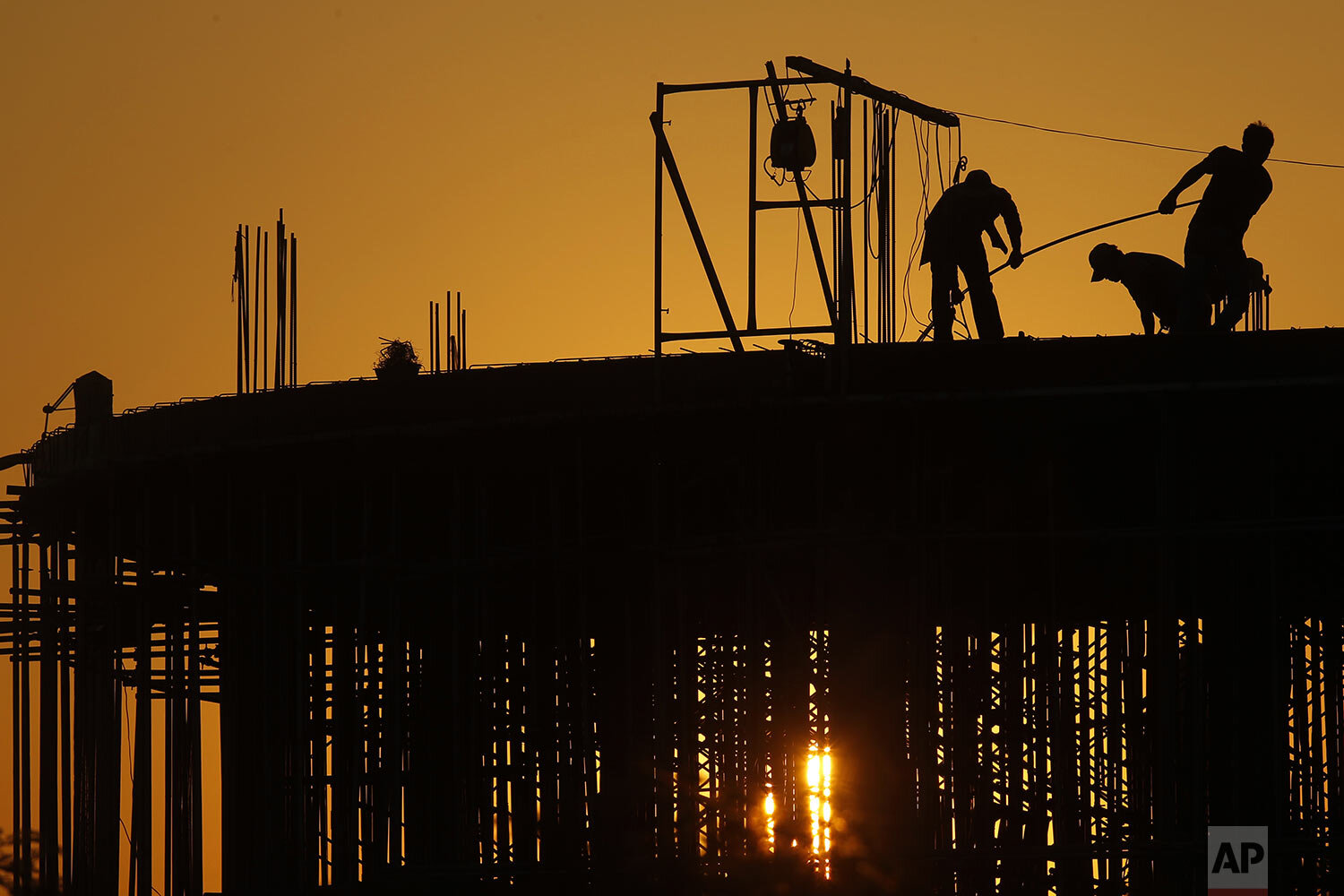  Workers are silhouetted at a building construction site near Phnom Penh, Cambodia, Thursday, Dec. 26, 2019. (AP Photo/Heng Sinith) 