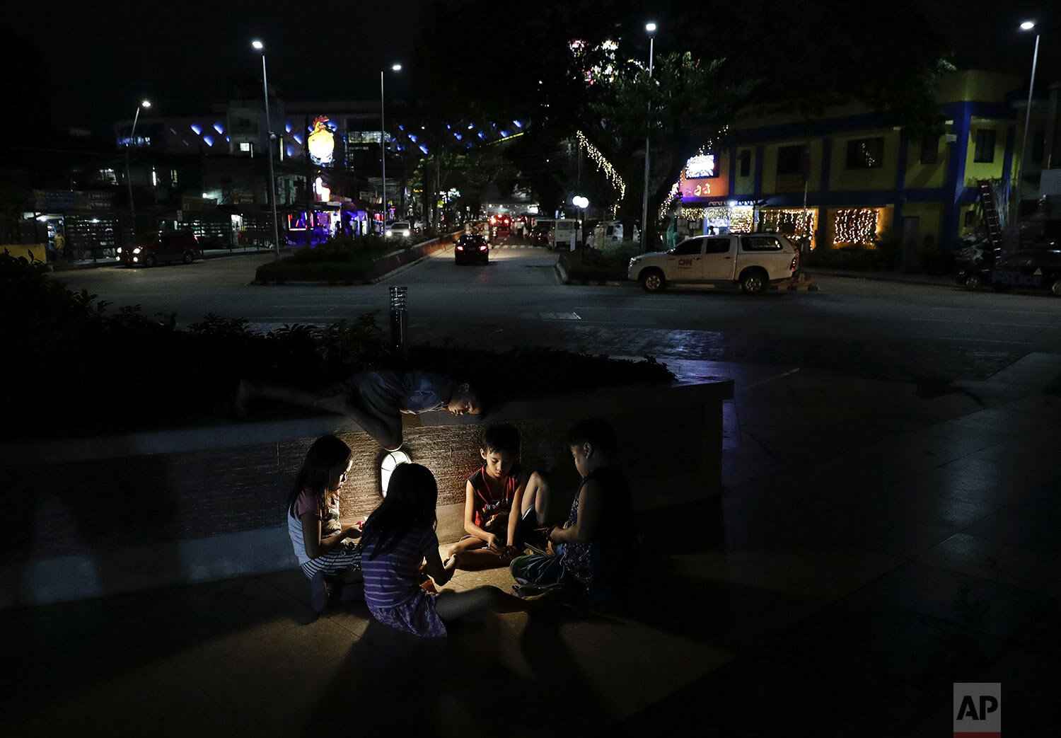  Children play beside a street lamp in Quezon city, Metro Manila, Philippines on Wednesday, Dec. 18, 2019. (AP Photo/Aaron Favila) 
