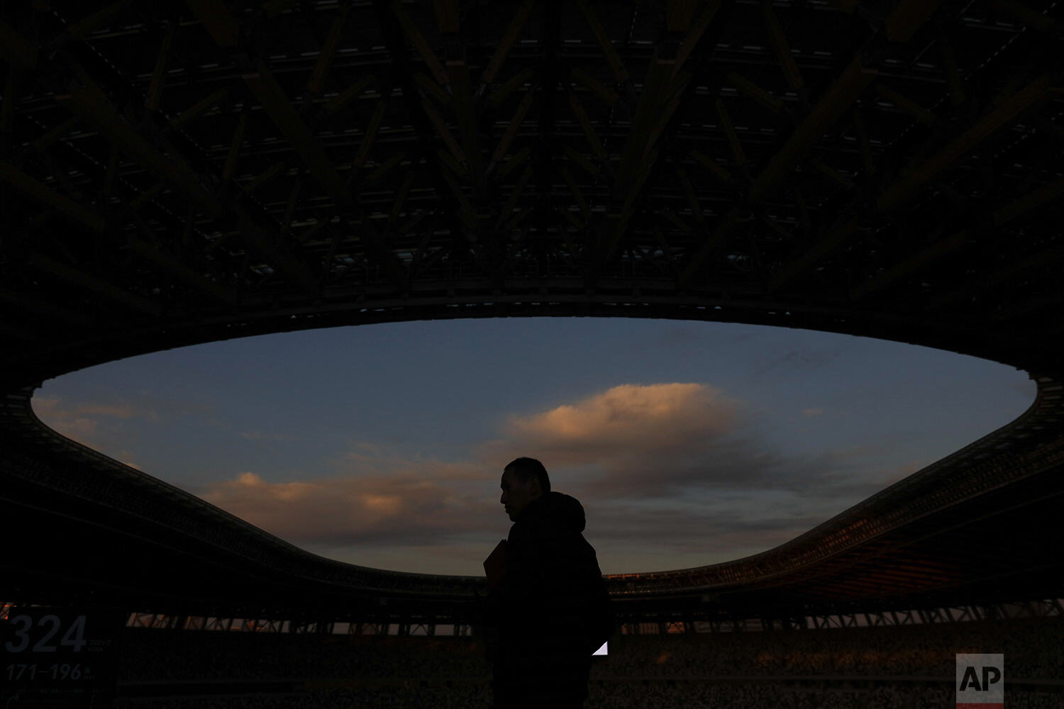  A man is silhouetted against the sky during a tour at the new National Stadium Sunday, Dec. 15, 2019, in Tokyo. (AP Photo/Jae C. Hong) 