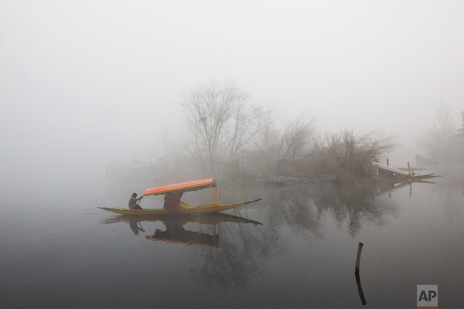  A Kashmiri boatman rows his boat on the Dal Lake surrounded by dense fog on a cold morning in Srinagar, Indian controlled Kashmir, Saturday, Dec. 7, 2019. (AP Photo/ Dar Yasin) 
