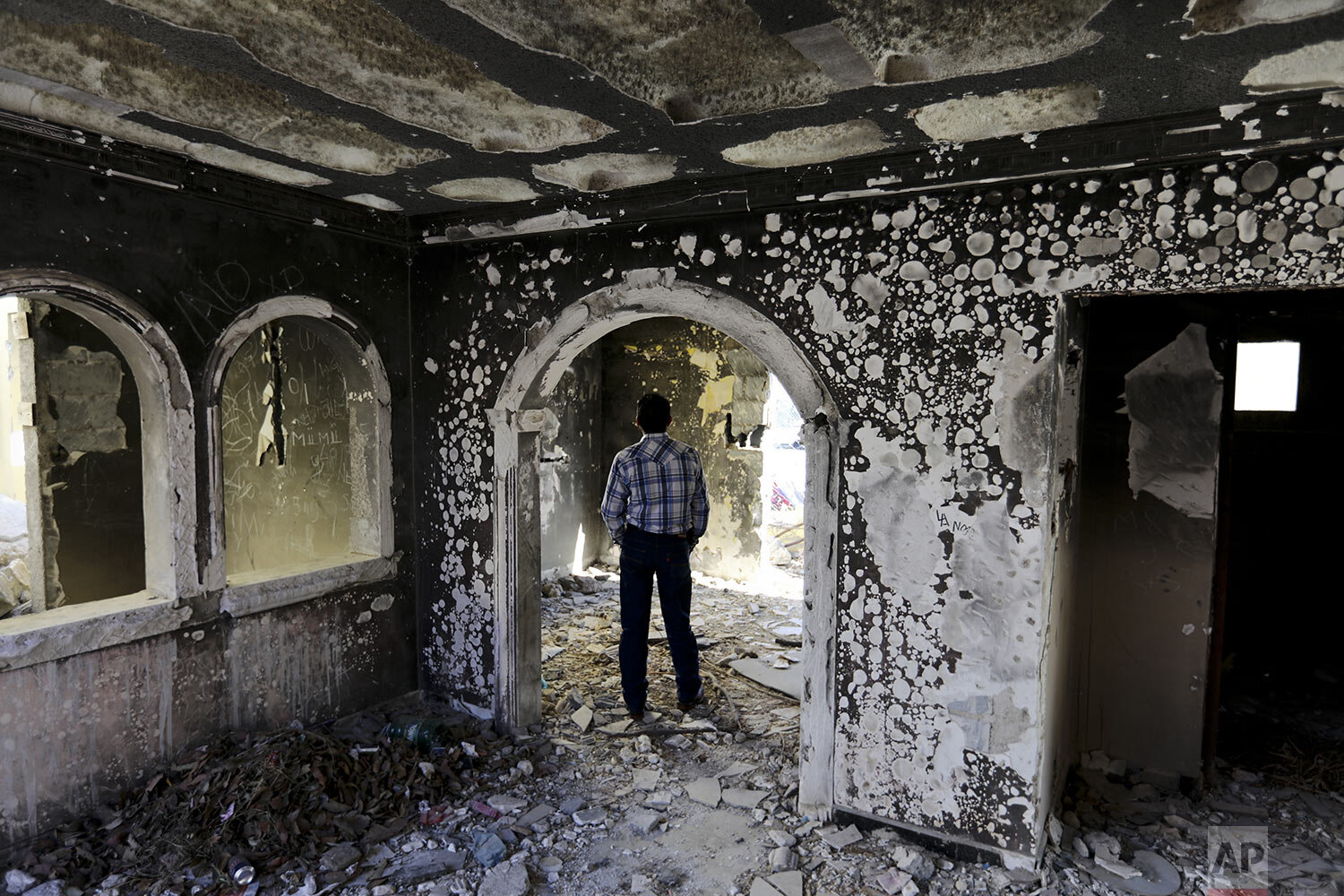  A former policeman walks through an abandoned home, torched by the Zetas cartel eight years ago in Allende, Coahuila state, Mexico, Dec. 3, 2019. In an act of revenge cartel members in 2011 razed and burned houses and disappeared people just by bear