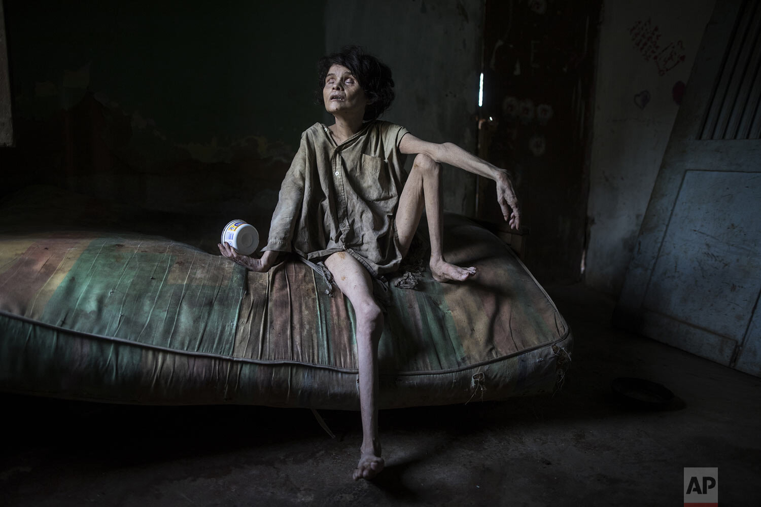  In this photo published in December, Zaida Bravo, who suffers Parkinson's disease and is malnourished, waits for dinner on her dirty mattress in her one room living quarters in Maracaibo, Venezuela, Nov. 28, 2019. The 48-year-old's sister Ana Bravo 