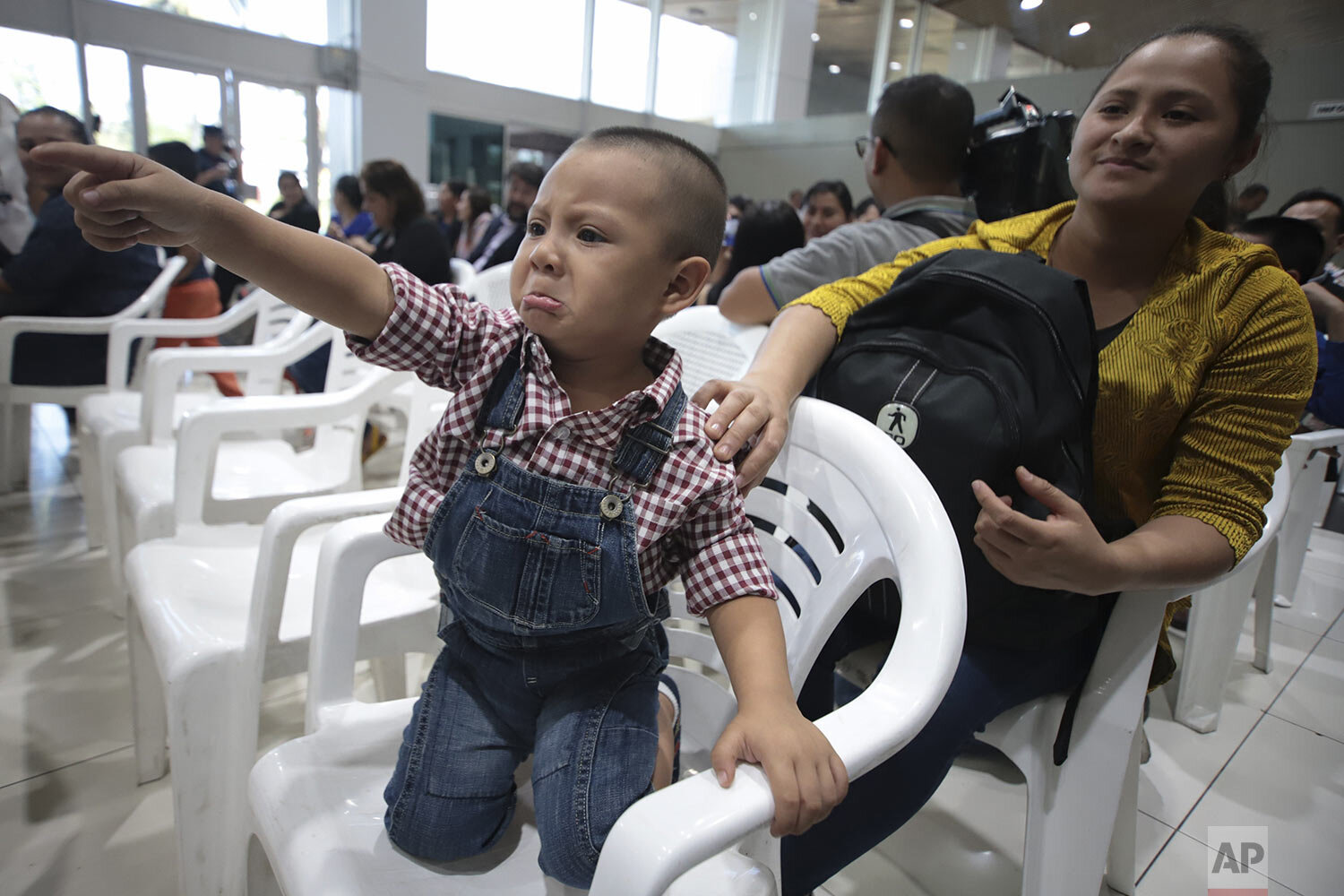  Isaac Tepas, comforted by his mother Alba Marquez de Tepas, points toward his father William Tepas who departs with a group of Salvadorans granted temporary visas to work on a rose farm in Mississippi, following a send-off event at El Salvador Inter