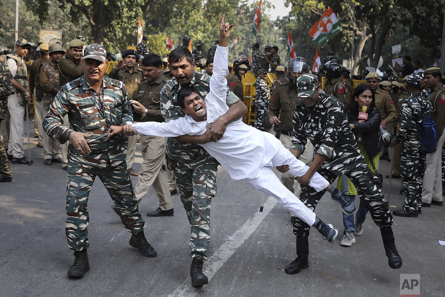  Indian paramilitary soldiers detain a Congress party supporter during a protest against the withdrawal of Special Protection Group (SPG) cover to party president Sonia Gandhi, her children Rahul Gandhi and Priyanka Vadra and former prime minister Ma