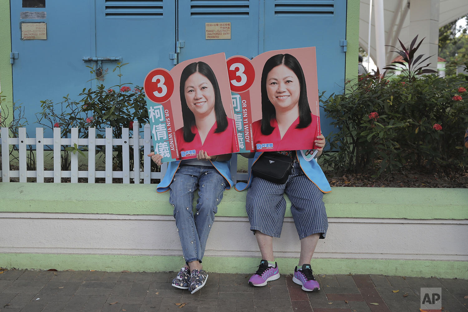  Supporters of pro China candidate Or Sin-yi Windy hold her promotional placards in Hong Kong, Sunday, Nov. 24, 2019. (AP Photo/Kin Cheung) 