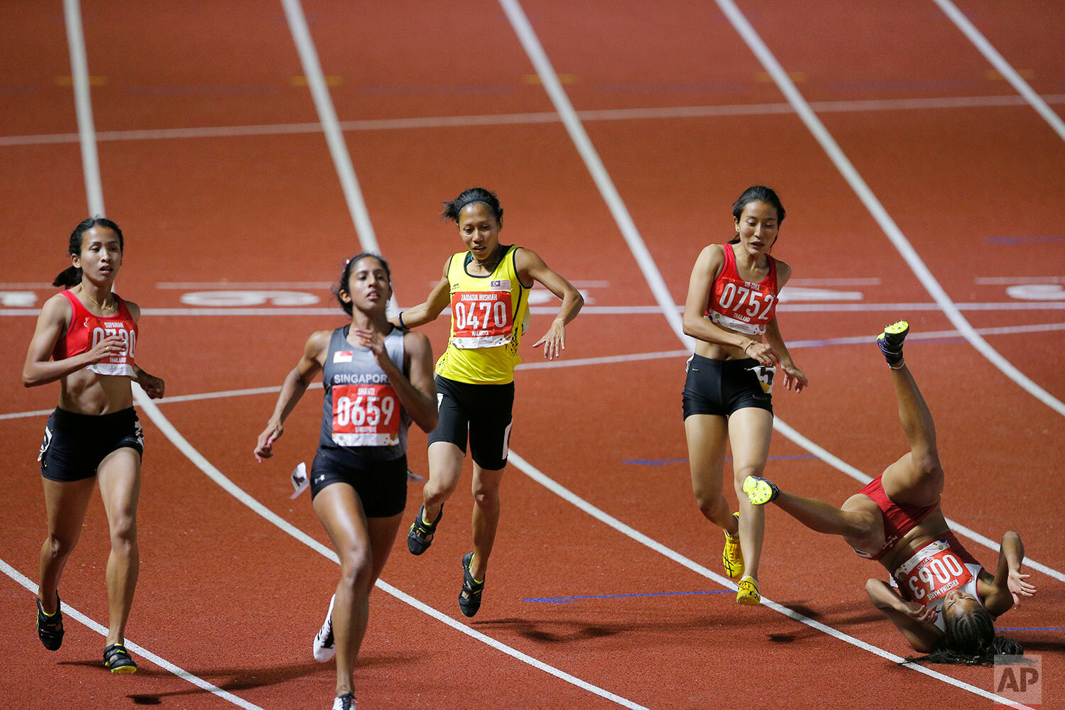   Philippine's Kristina Marie,right, falls down in the women's 100m final during the athletics competition at the 30th Southeast Asian Games at Athletics Stadium in New Clark City, Tarlac province, northern Philippines on Sunday, Dec. 8, 2019. The So
