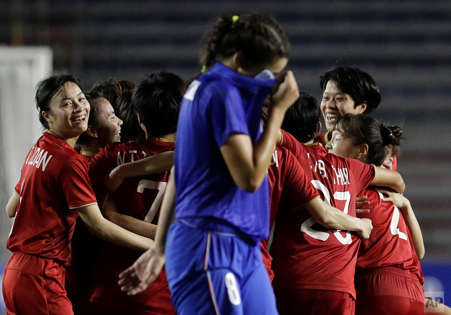  Vietnamese players celebrate while a Thai player passes by after their womenÅfs football finals match at the 30th South East Asian Games in Manila, Philippines on Sunday Dec. 8, 2019. Vietnam won gold. The Southeast Asian Games, also known as the SE