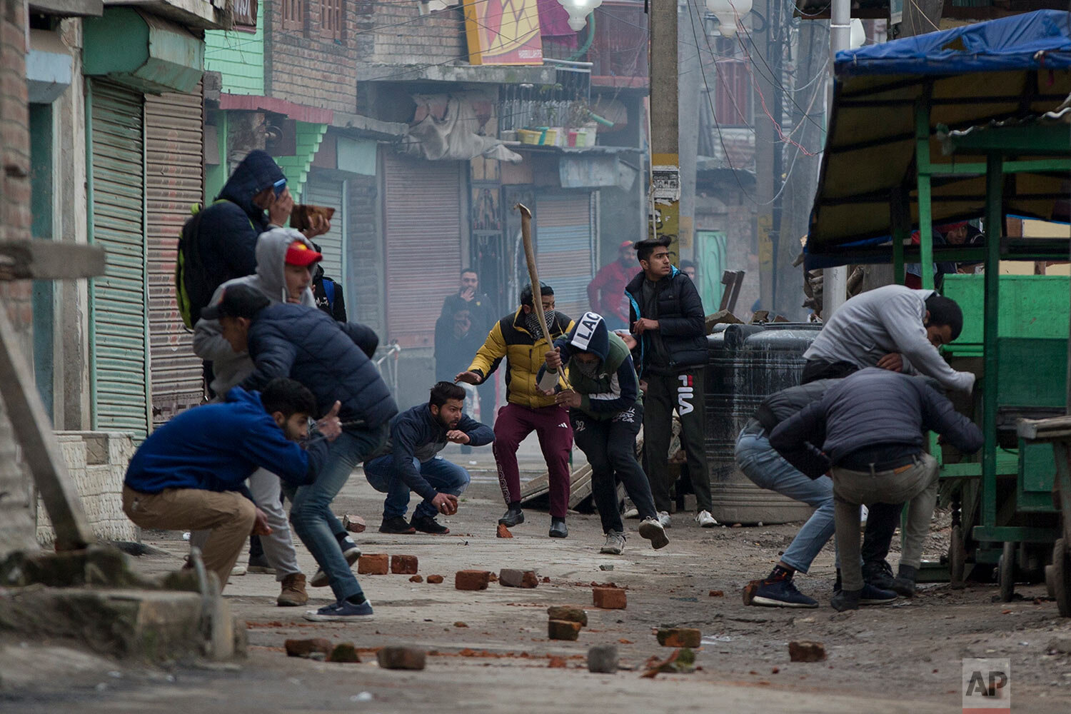 Kashmiri protesters run for cover as they during clash with Indian police men in Srinagar, Indian controlled Kashmir, Tuesday, Feb. 26, 2019. (AP Photo/Dar Yasin)