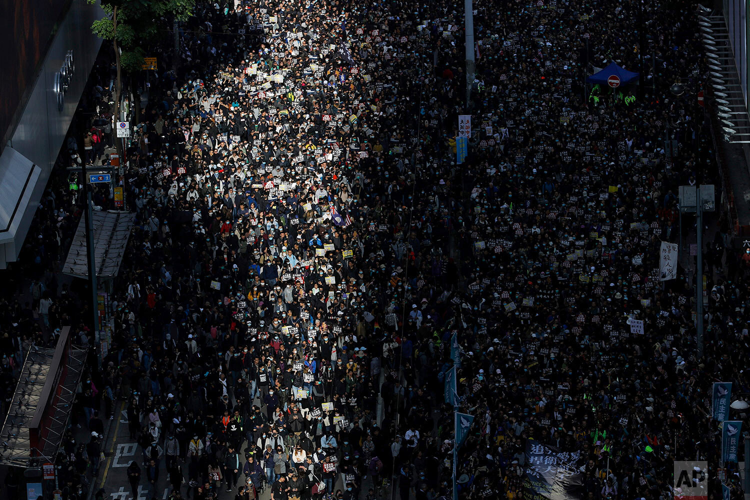  A beam of sunlight shines on pro-democracy protesters as they march on a street in Hong Kong, Sunday, Dec. 8, 2019. Thousands of people took to the streets of Hong Kong on Sunday in a march seen as a test of the enduring appeal of an anti-government