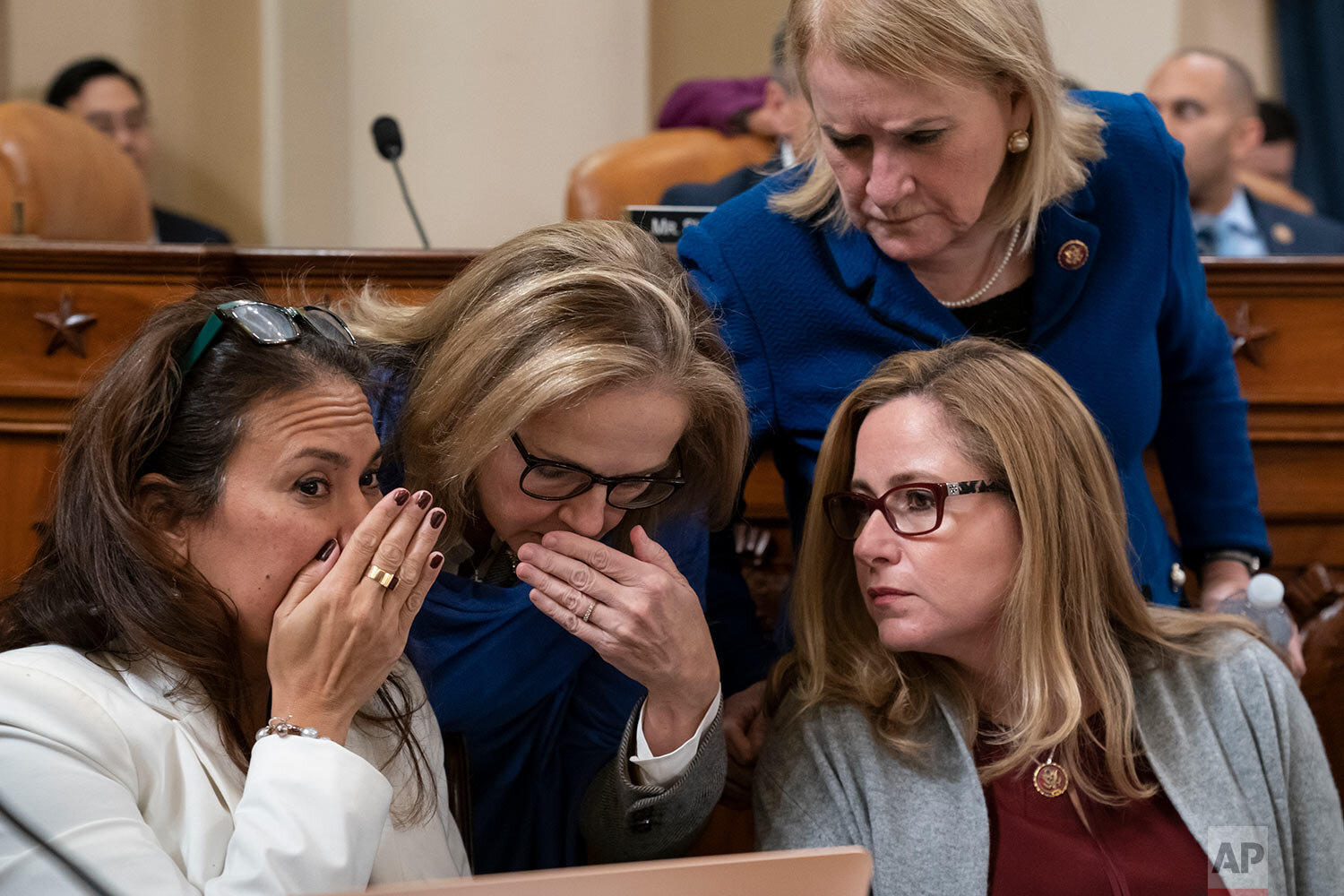  From left, Rep. Veronica Escobar, D-Texas, Rep. Madeleine Dean, D-Pa., and Rep. Debbie Mucarsel-Powell, D-Fla., joined at top right by Rep. Sylvia Garcia, D-Texas, confer with each other as the House Judiciary Committee marks up articles of impeachm