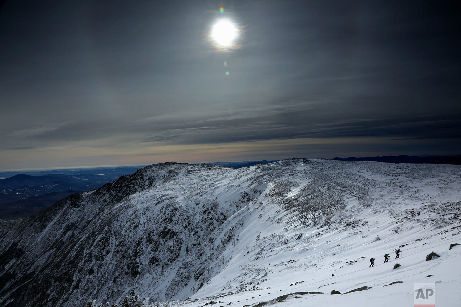  Under a midday winter solstice sun, a trio of climbers make their way up a slope on Mount Washington, Saturday, Dec. 21, 2019, in New Hampshire. Neither the sun nor the mercury rose very high as temperatures barely climbed out of the single digits o