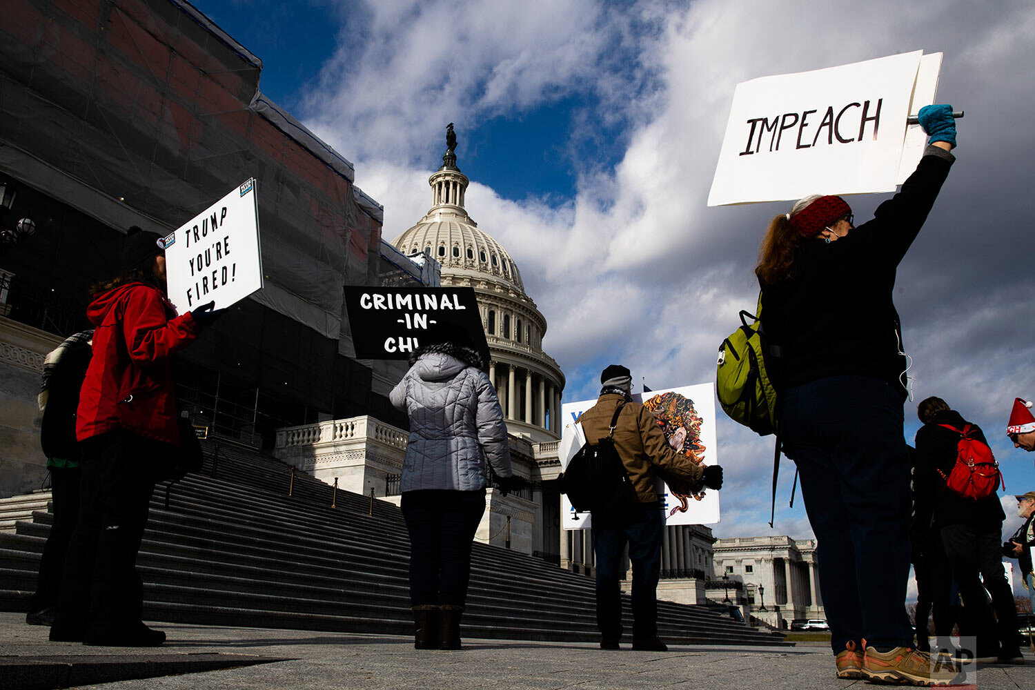  Protesters demonstrate as the House of Representatives debates on the articles of impeachment against President Donald Trump at the U.S. Capitol building, Wednesday, Dec. 18, 2019, on Capitol Hill in Washington. (AP Photo/Matt Rourke) 
